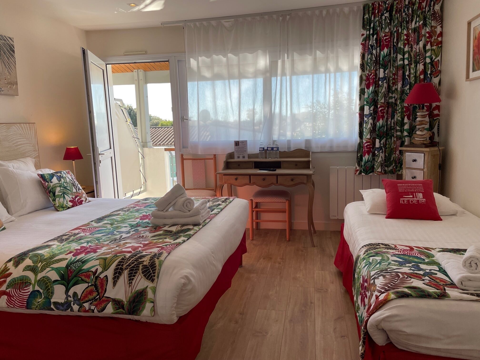 A hotel room with two beds, a desk, and a chair.
