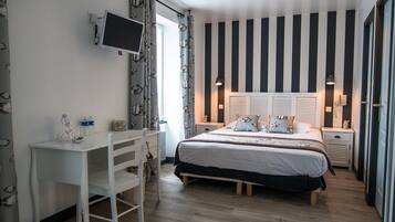 A bedroom with a bed, bedside tables, a desk, and a chair.