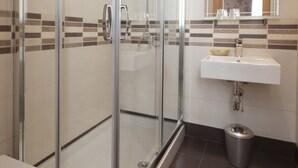 A modern bathroom with a glass-enclosed shower, a white sink, and a mirror above it. - Jemasaca Palma 61 (Madrid)