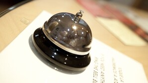 A black bell with a transparent dome on a white sign with text. - Jemasaca Palma 61 (Madrid)
