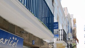 A building with a sign reading "Cridel" and another sign for "Benvinguts". - Hostal Pensió Maricel (Sitges)