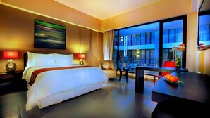 Una habitación de hotel moderna con una cama grande, un escritorio y vistas del exterior del edificio.