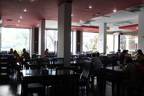 Un restaurante espacioso con techos altos, ventanas amplias y un diseño interior moderno.