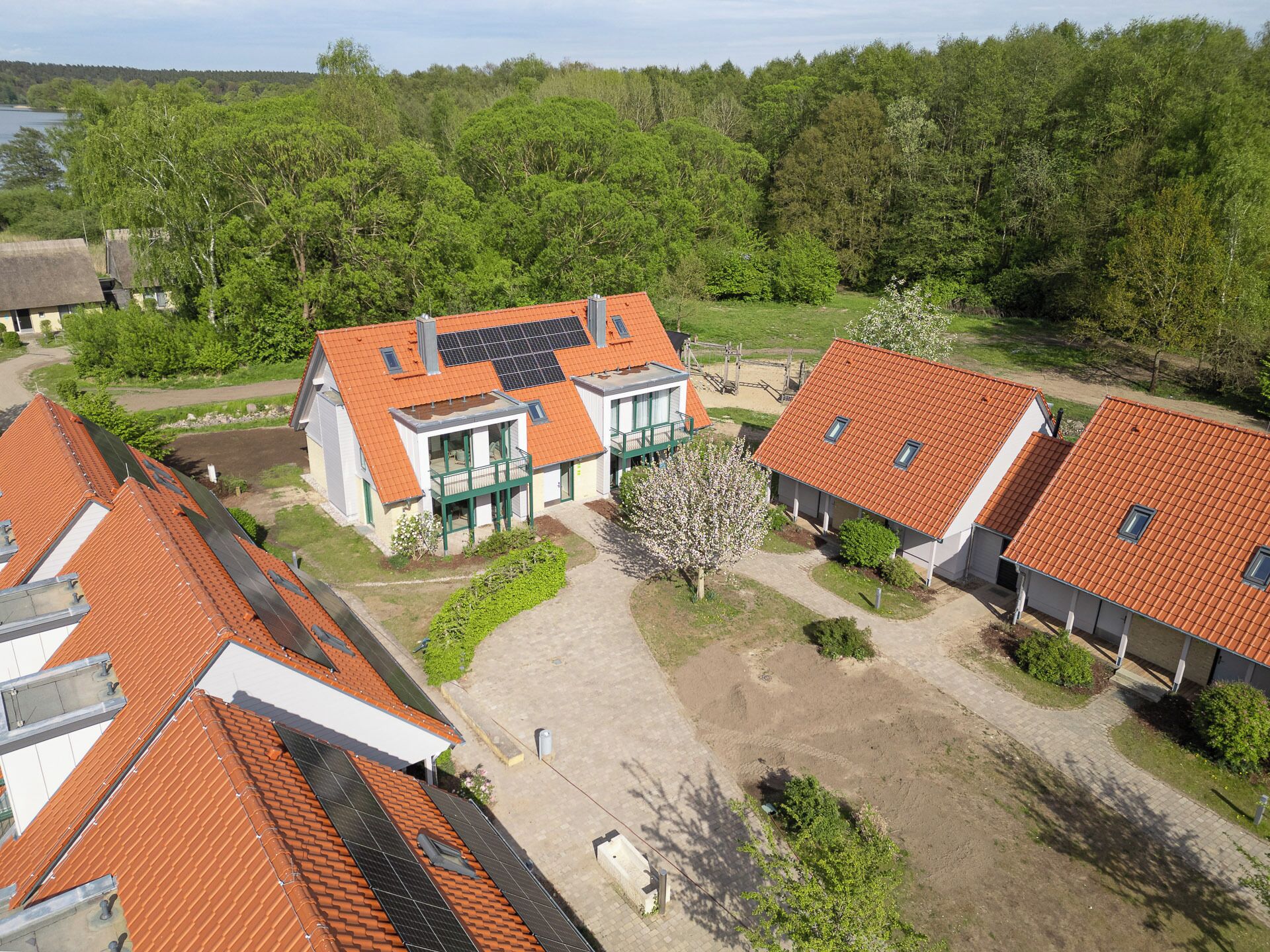 A residential area with houses featuring red-tiled roofs and solar panels.