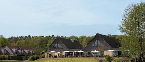 A building with multiple rooms and a covered outdoor seating area.