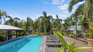 A swimming pool with lounge chairs and potted plants. - Orator Hotel Samoa (Apia)