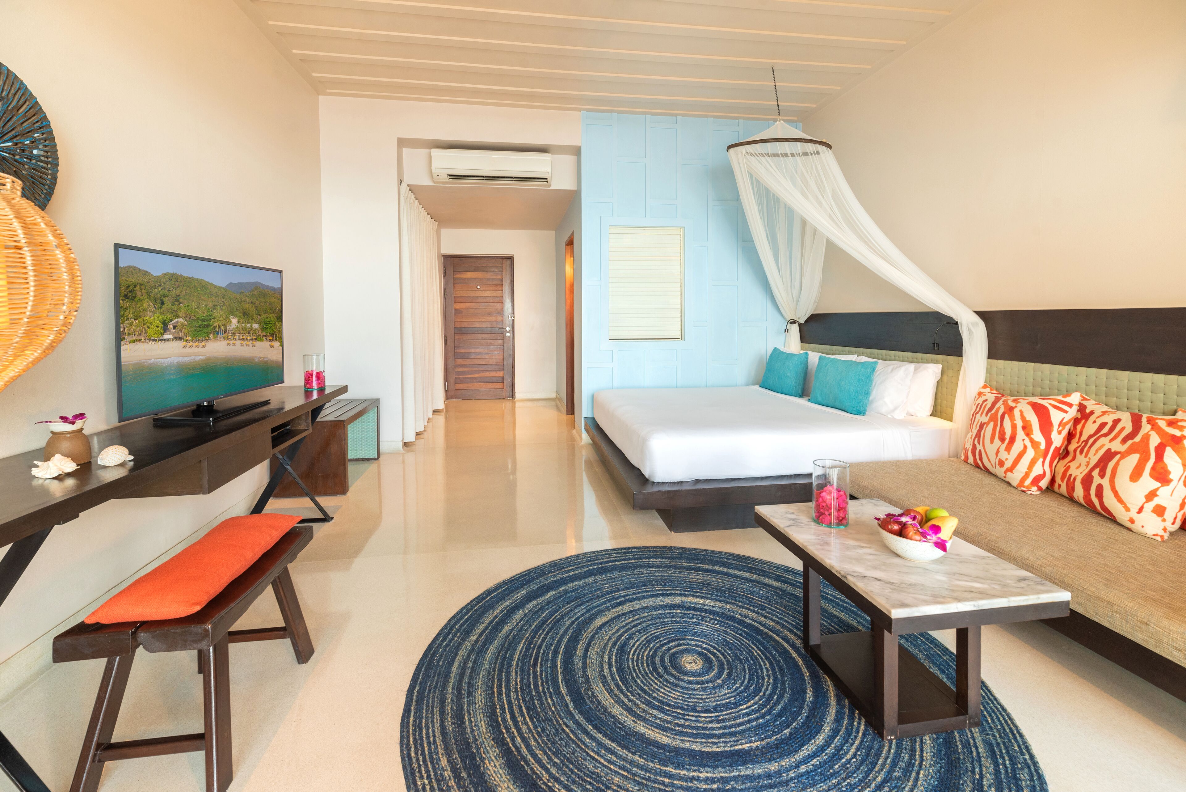 A hotel room with a bed, a desk, a television, a window, and a bathroom.