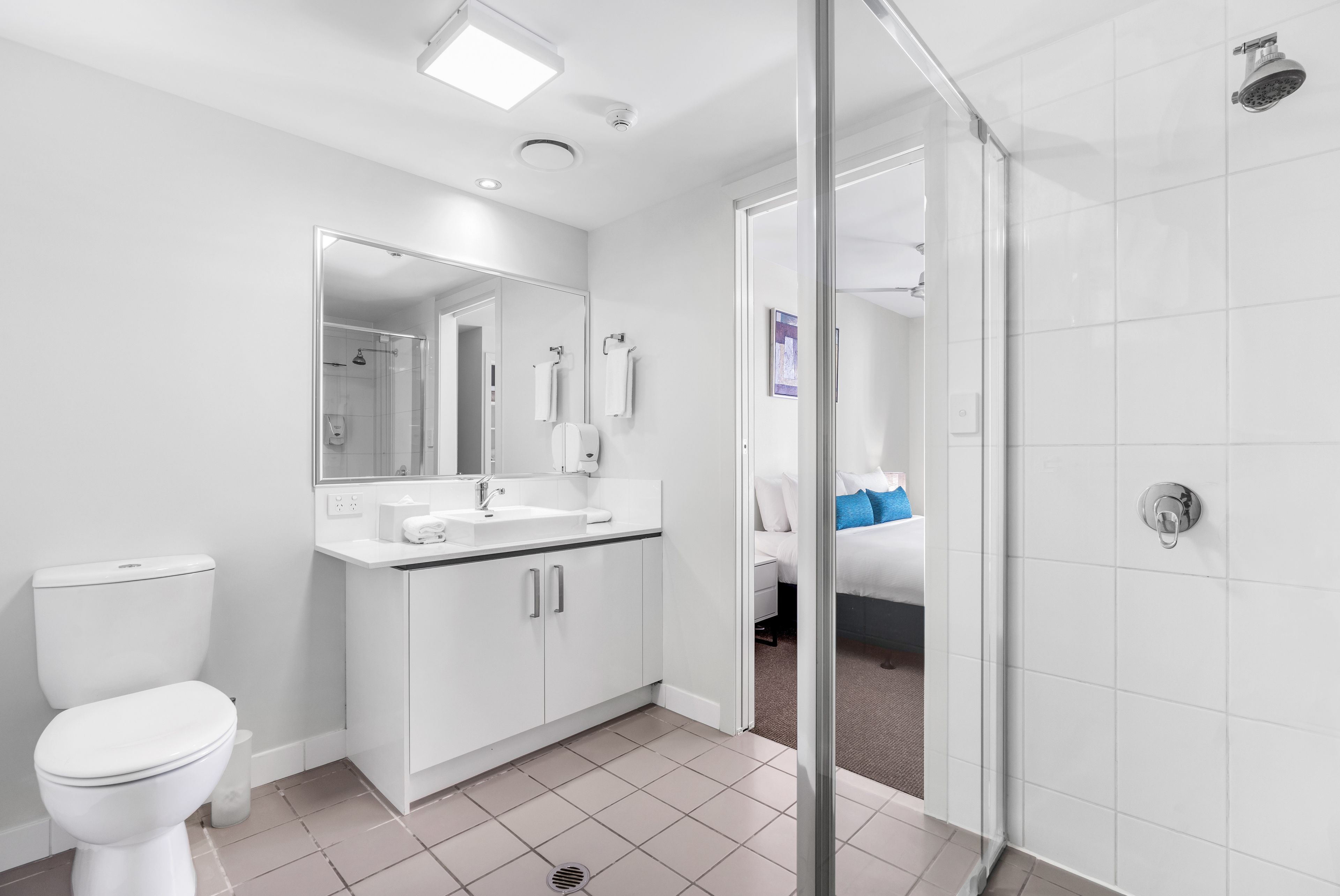 A modern bathroom with a toilet, sink, and shower.