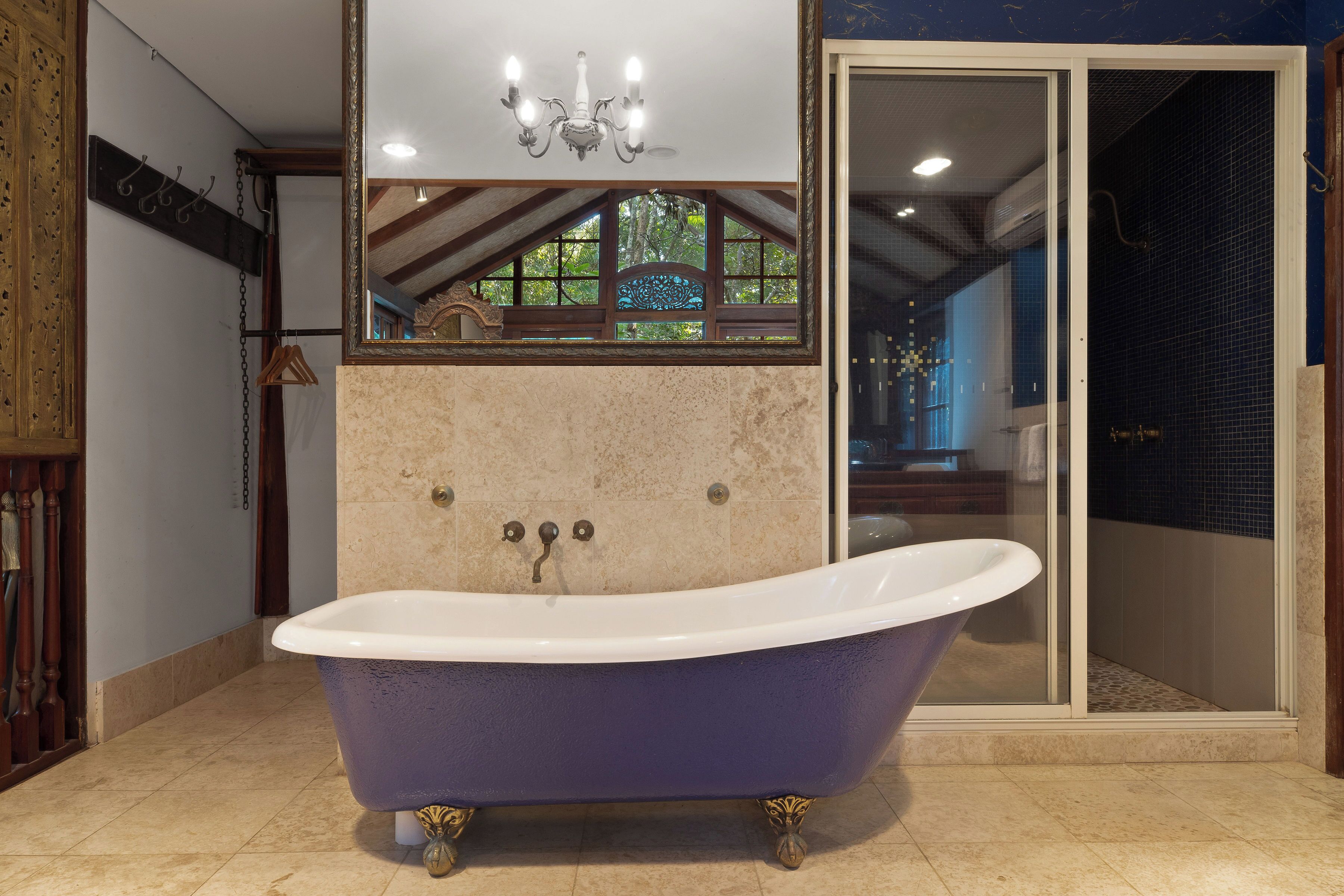 A bathroom with a freestanding bathtub, a mirror, and a shower area.