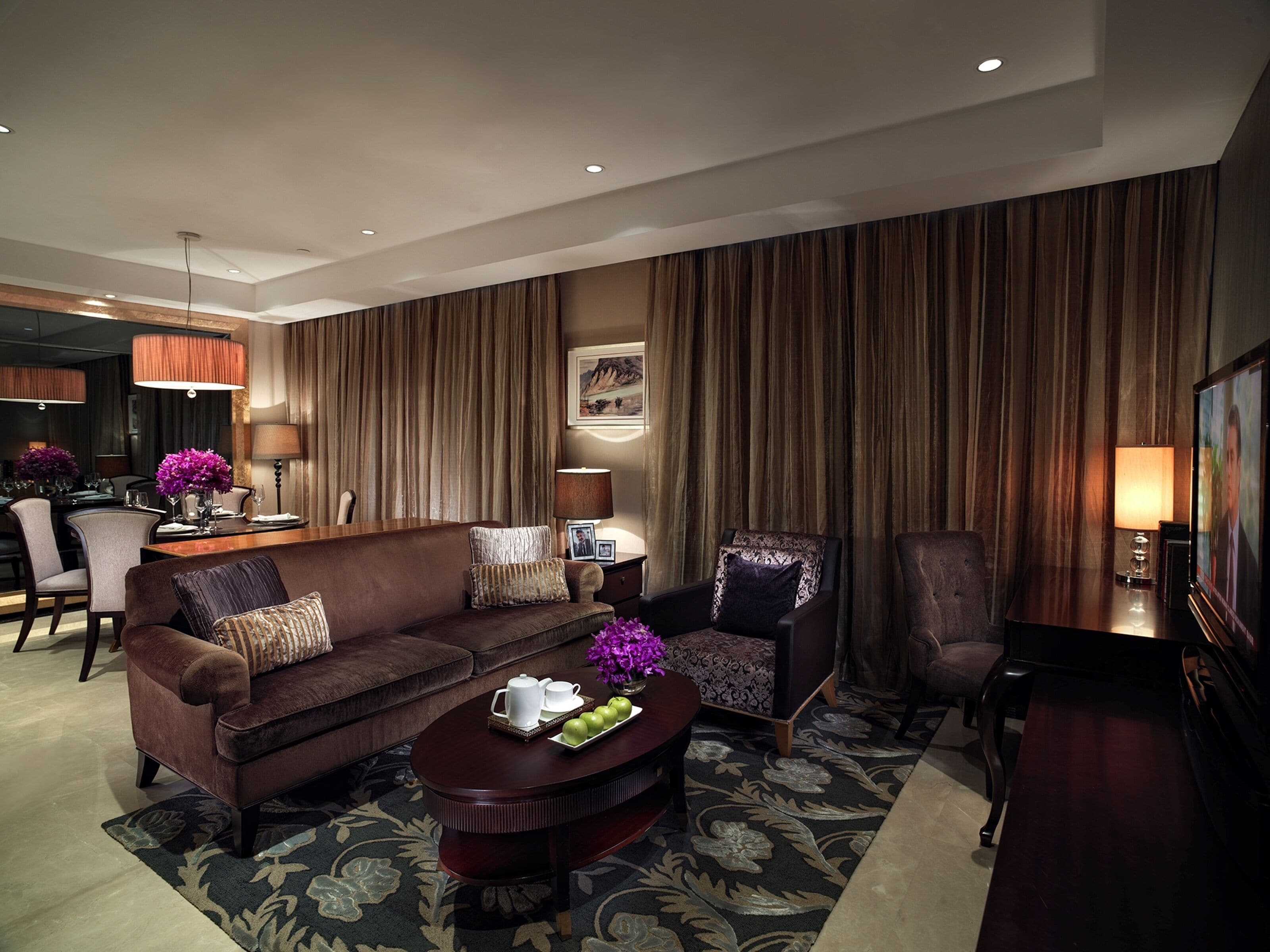 A modern living room with a brown sofa, a coffee table, and a television.