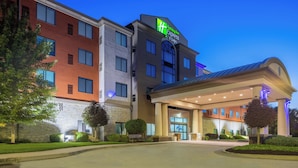 Et Holiday Inn Express hotel med en moderne facade, store vinduer og et godt oplyst indgangsparti.