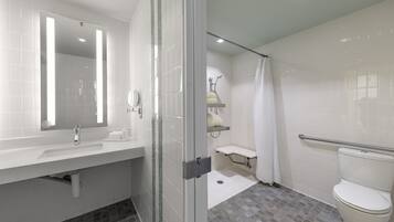 Un baño moderno con un lavabo blanco, espejo e inodoro.
