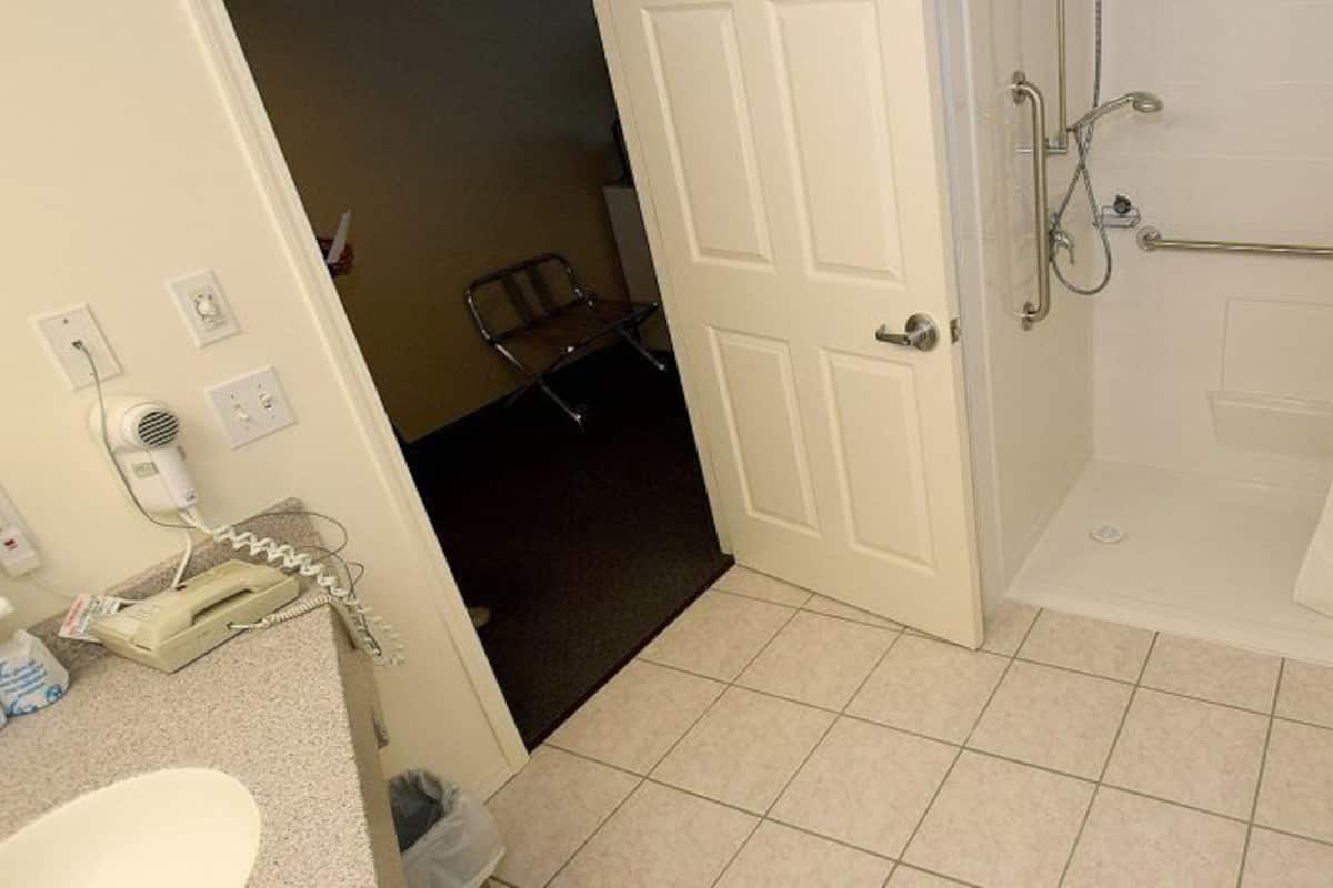 Une salle de bain comprenant une douche, des toilettes, un lavabo et un porte-serviettes.