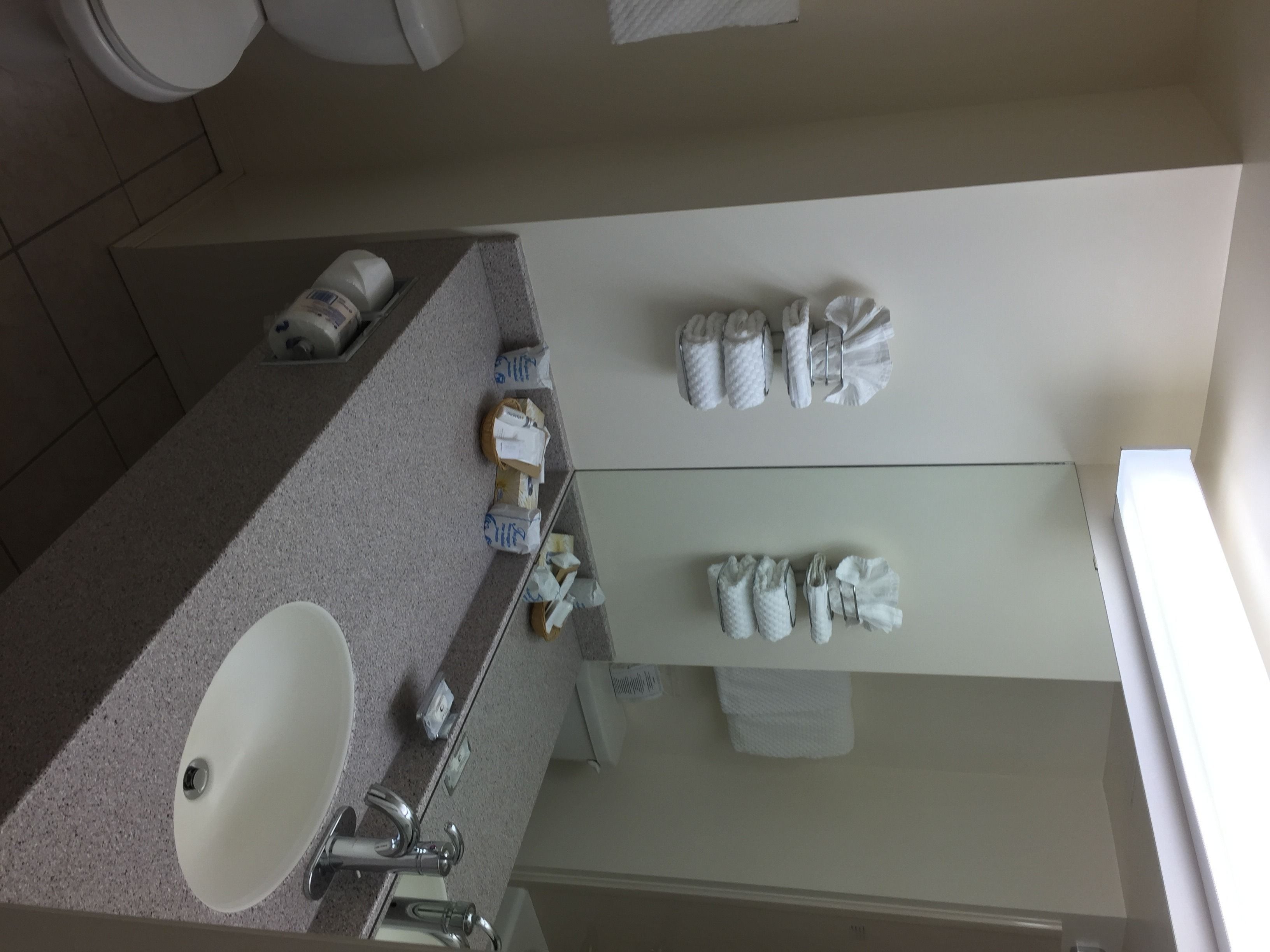 A bathroom with a sink, mirror, and towel rack.