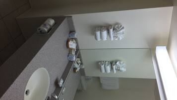 A bathroom with a sink, mirror, and towel rack.