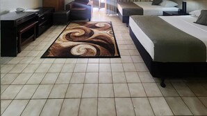 A hotel room with a bed, a desk, a chair, a TV, and a view of the outdoors. - Insel Fehmarn Hotel (Apia)
