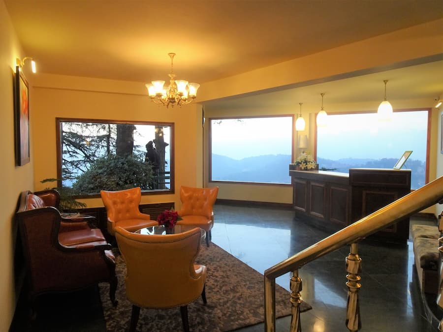 A spacious room with a large window offering a mountain view, a chandelier, and a dining area with a table and chairs.