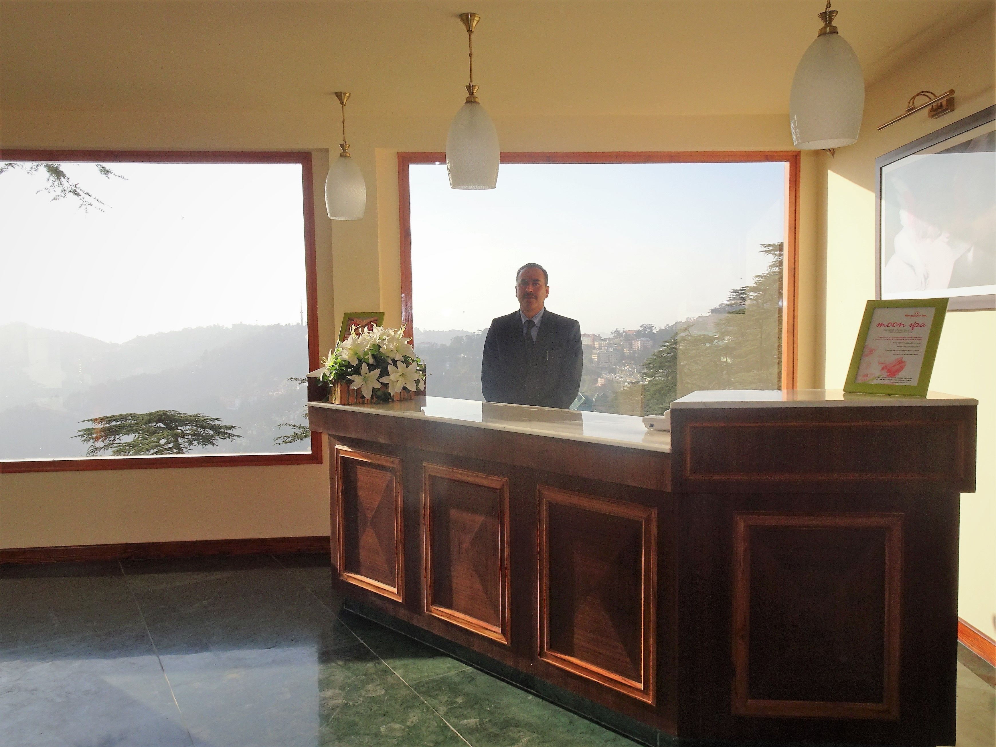 Una reception con vista sulle montagne, un quadro appeso al muro e un cartello per 'moon spa'.
