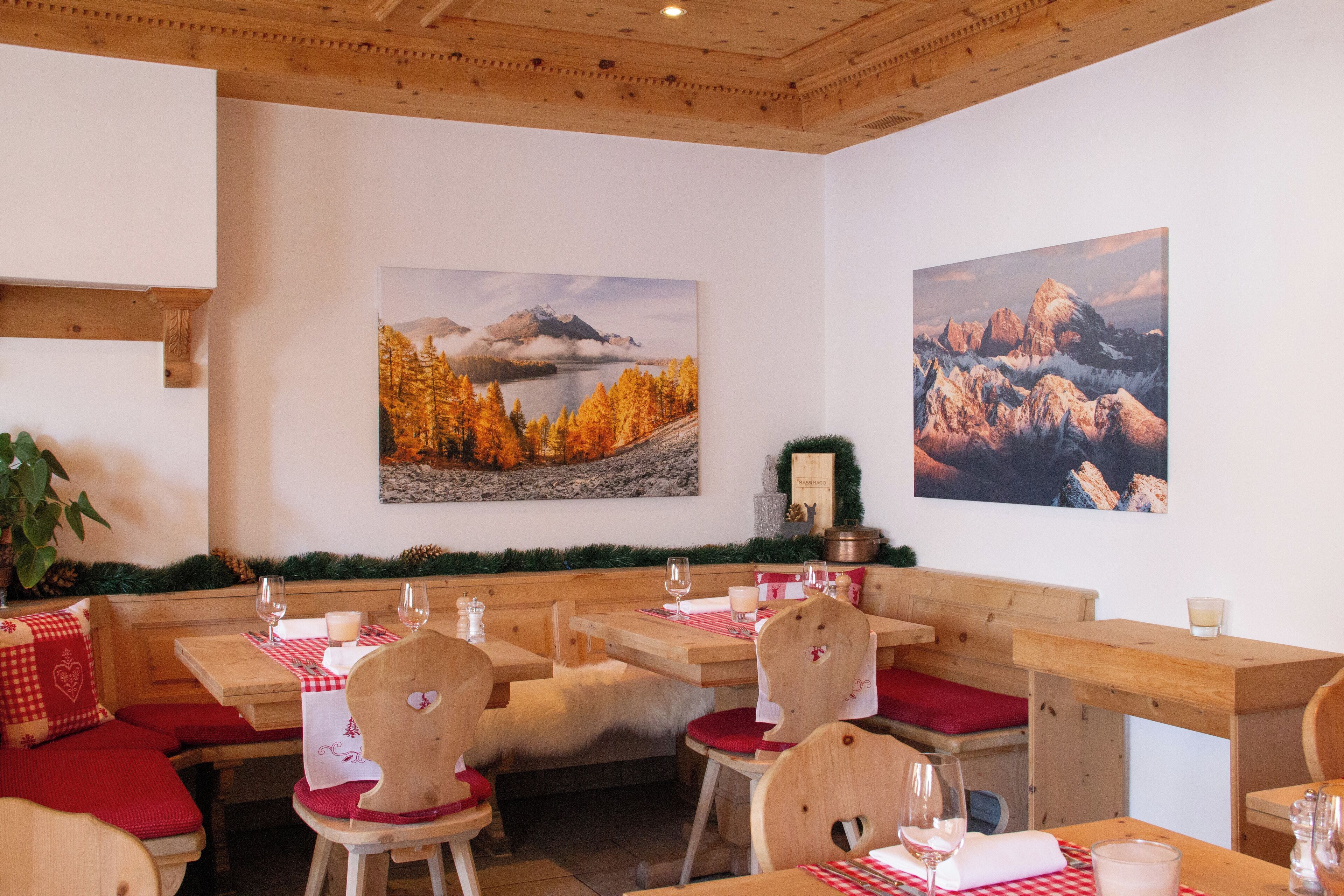 Un restaurant avec des bancs et des tables en bois, décoré de nappes à carreaux rouges et blancs.