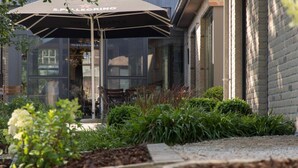 A restaurant with outdoor seating and a large umbrella. - 't Oud gemeentehuis Poelkapelle (Langemark-Poelkapelle)