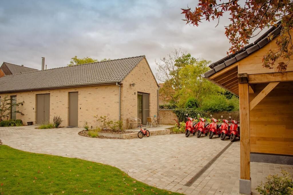 A building with a brick facade, a tiled roof, and a paved courtyard.