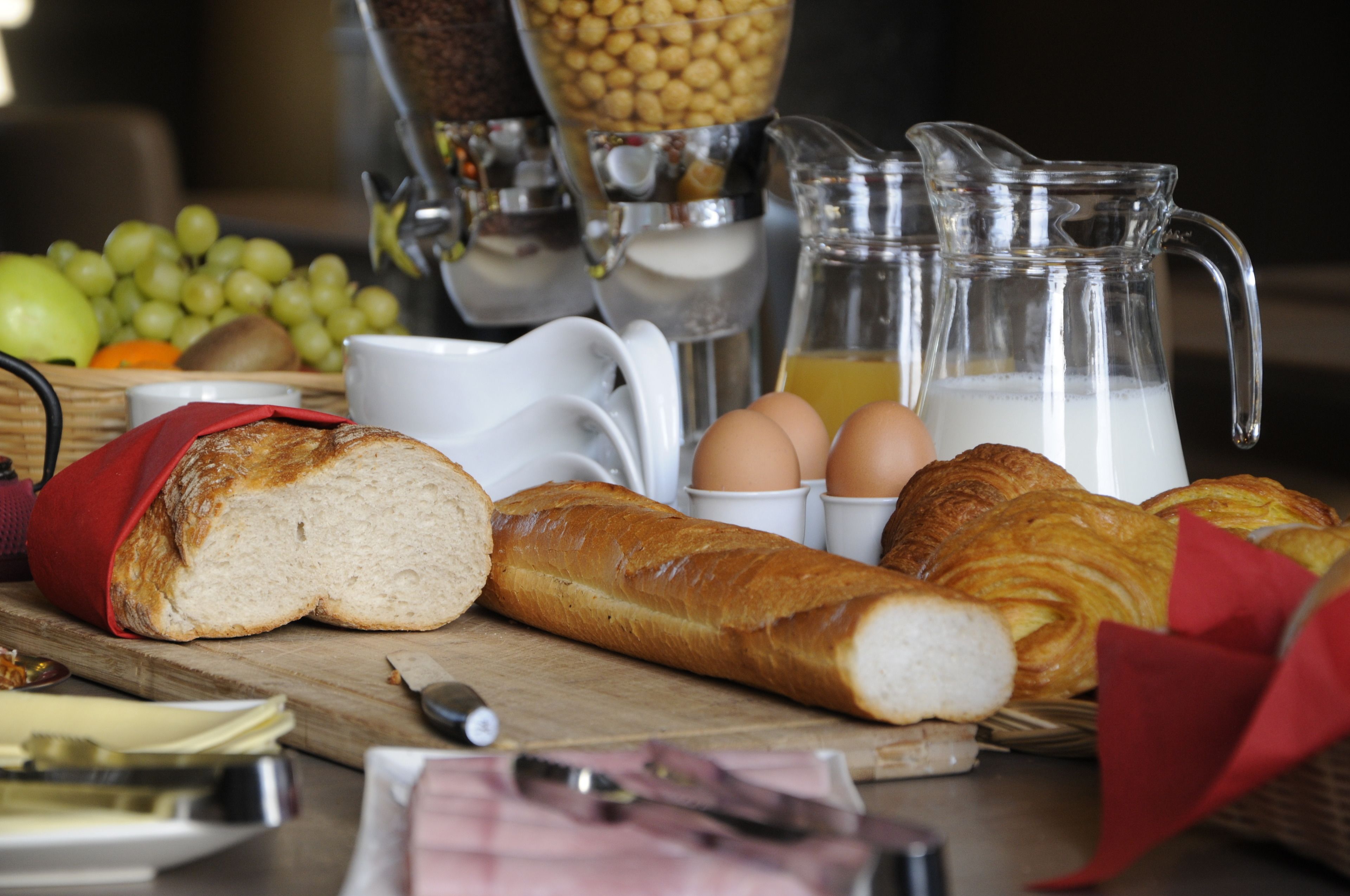 A breakfast setting with bread, eggs, and beverages.