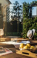 Un tavolo all'aperto con un cesto di pere, un cappello e un bicchiere d'acqua.