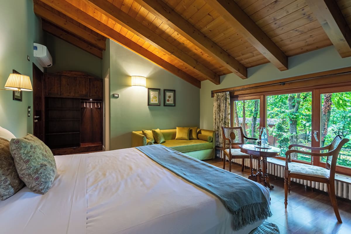 Un dormitorio con cama, sofá, mesa y sillas.