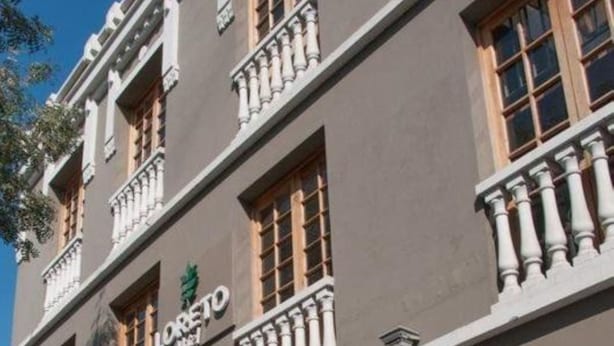 A hotel with a classic facade, featuring a prominent sign with the name 'LORETO Hotel'. - Hotel Loreto (Santiago)