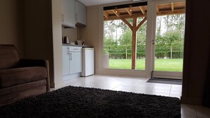 A modern kitchen with white cabinets, a coffee machine, and a refrigerator. There is a black rug on the floor and a wooden ceiling. - Maison Kerkhove (Avelgem)