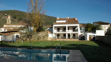 Una piscina al aire libre, sombrillas, tumbonas