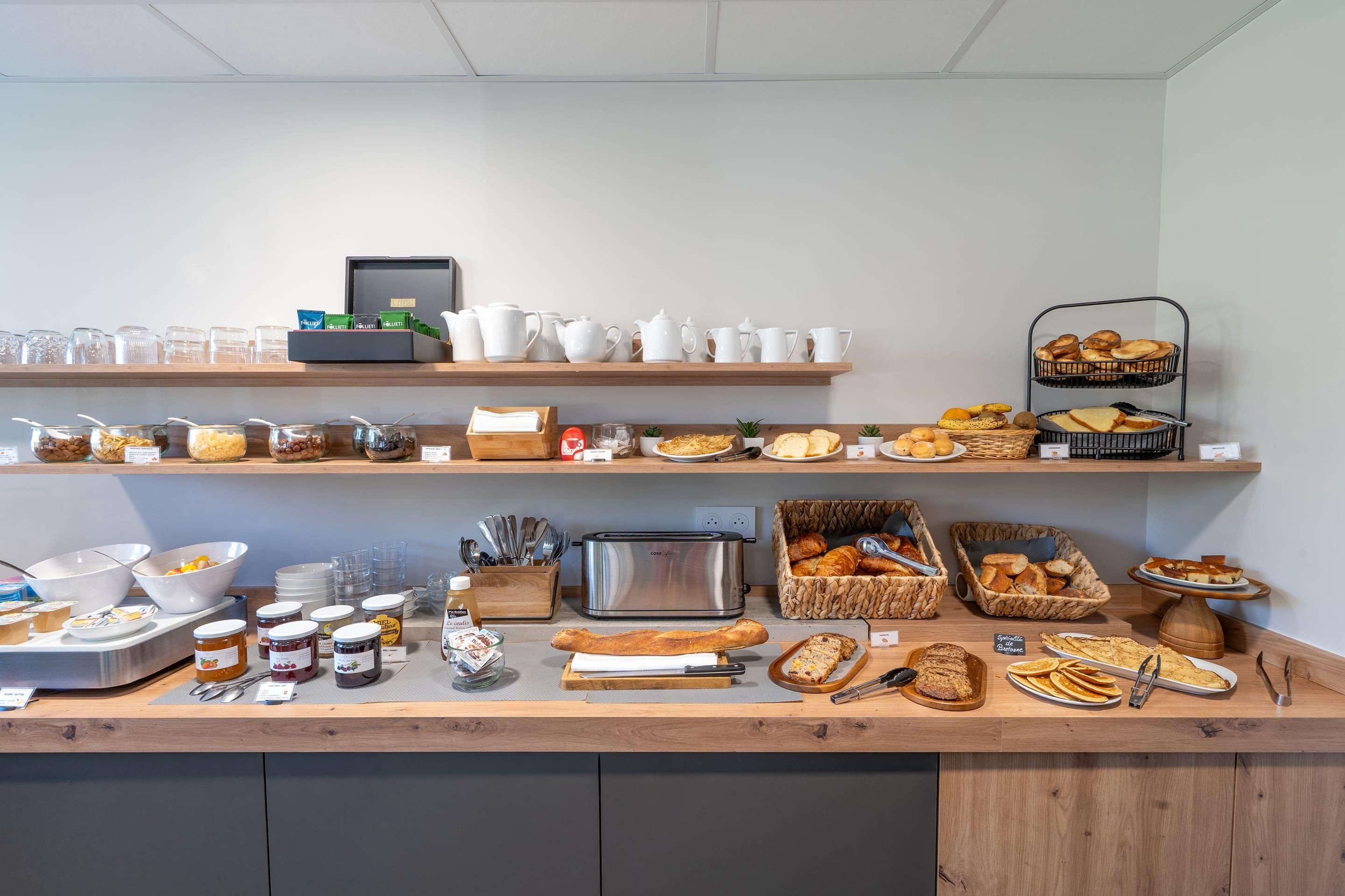 Un buffet de petit-déjeuner proposant une variété d'aliments, de couverts et un grille-pain.