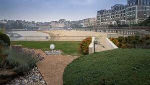A coastal cityscape with a beach, buildings, and a landscaped garden. - Best Western Hotel Le Crystal Dinard (Dinard)
