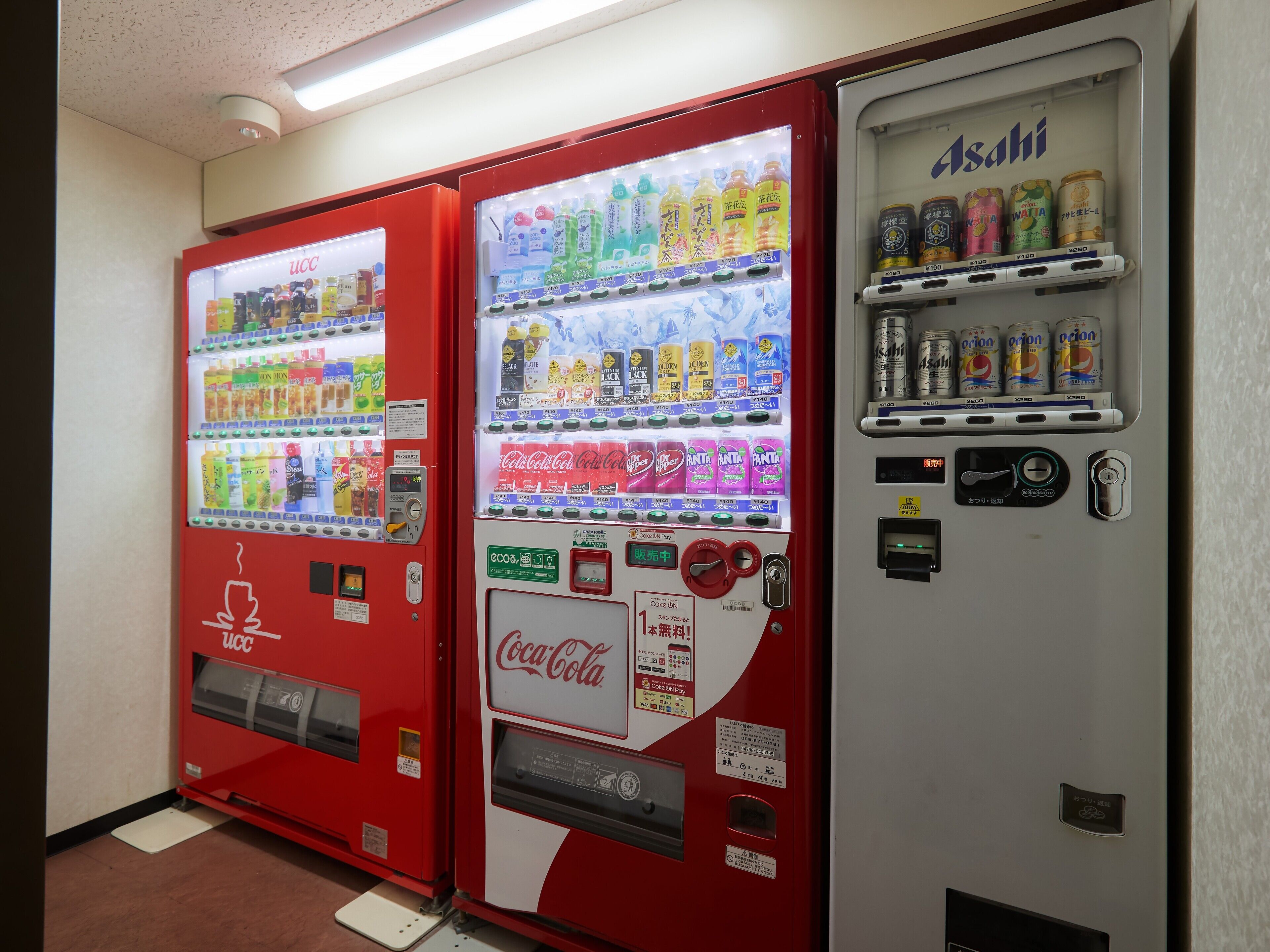 Three vending machines with various beverages and snacks.