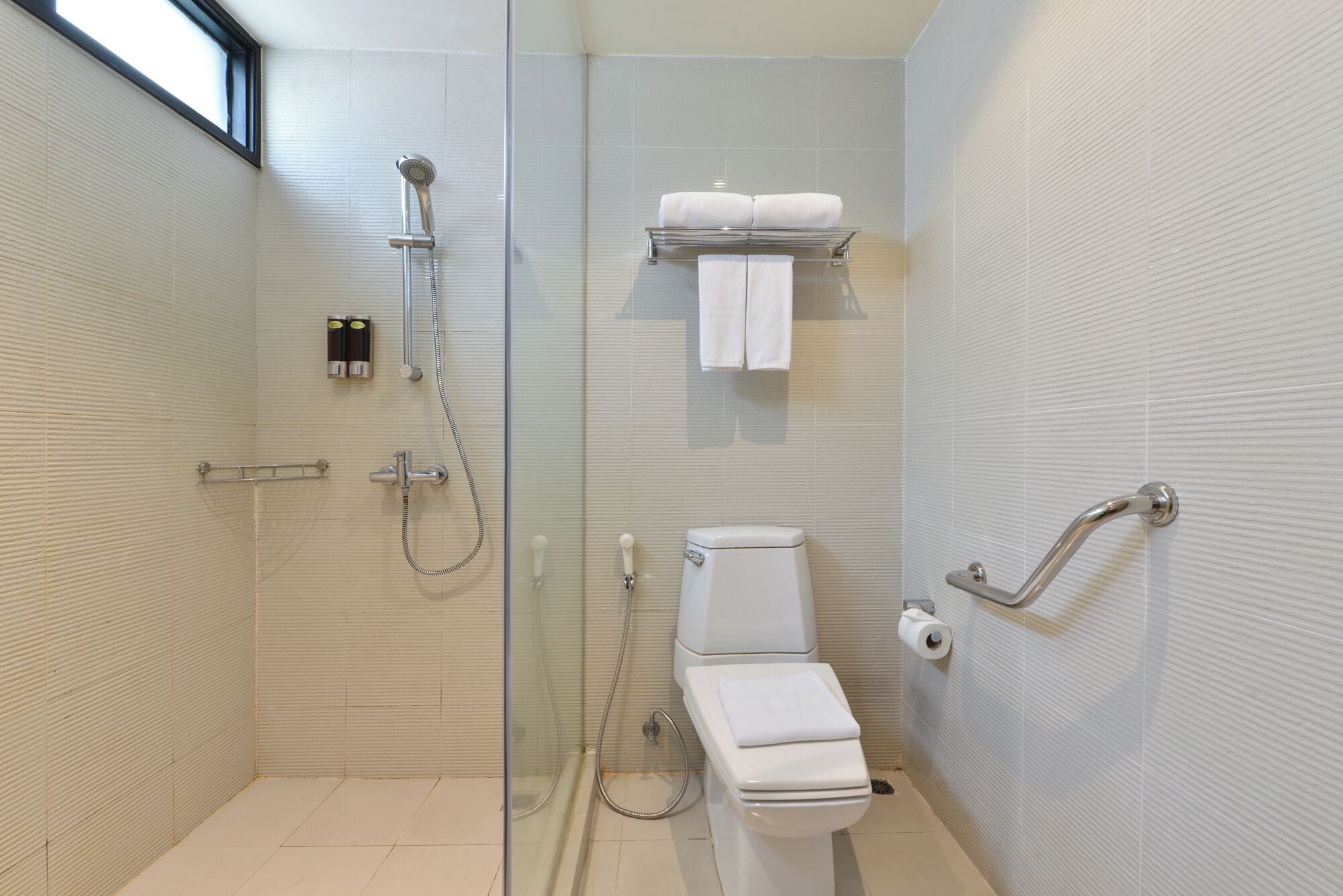 A modern bathroom with a glass-enclosed shower, a toilet, and a towel rack.