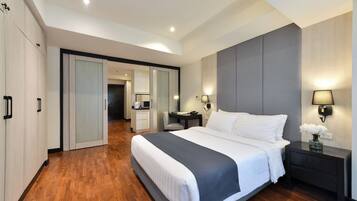 Quarto de hotel moderno com uma cama grande, uma escrivaninha e um closet espaçoso.