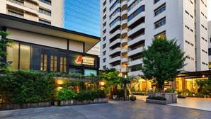 Un hôtel moderne doté d’un restaurant appelé « Hungry Brown » et d’un espace extérieur bien aménagé, agrémenté de plantes et de sièges.