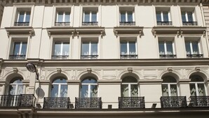A multi-story building with a classical architectural style, featuring arched windows and decorative moldings. - Grand Hôtel Richer (Paris)