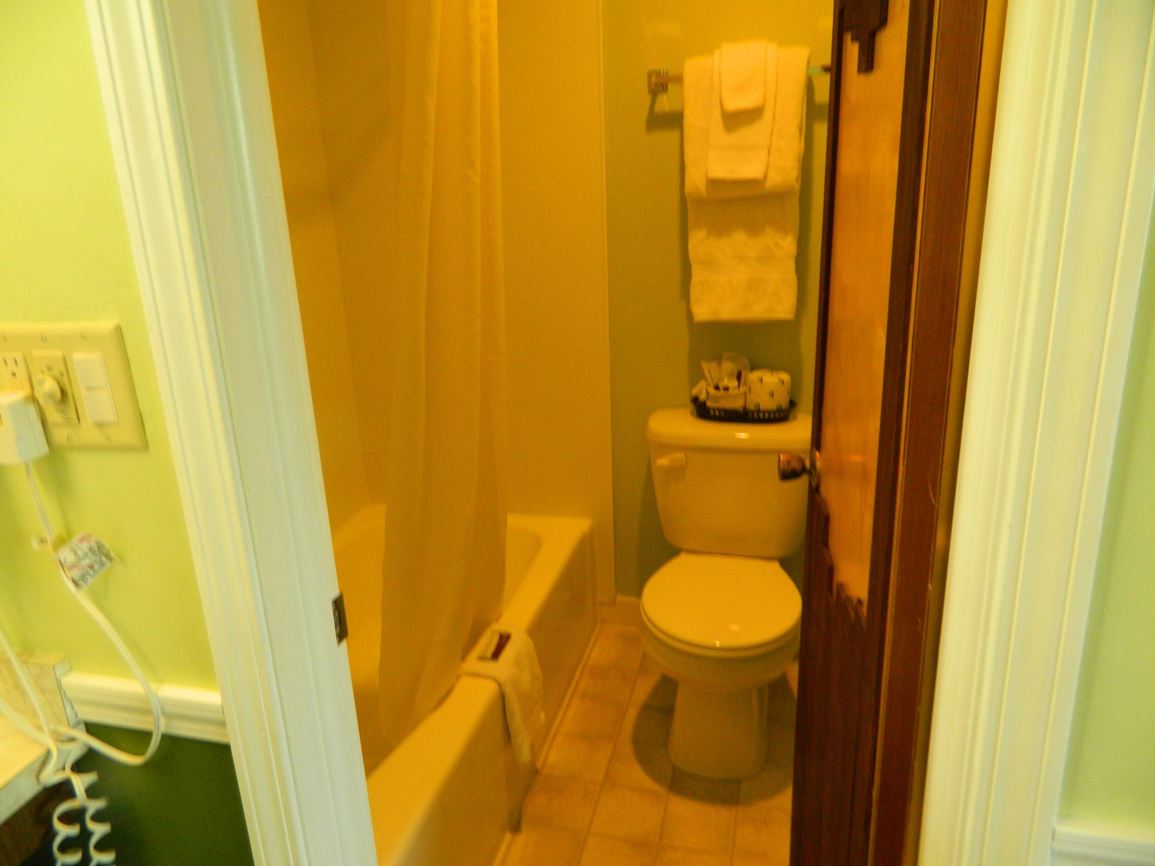 Un baño con inodoro, bañera y cortina de ducha.
