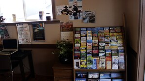 A room with a desk, a laptop, a bulletin board with various notices, and a bookshelf filled with books. - Country Motor Inn (Livingston)