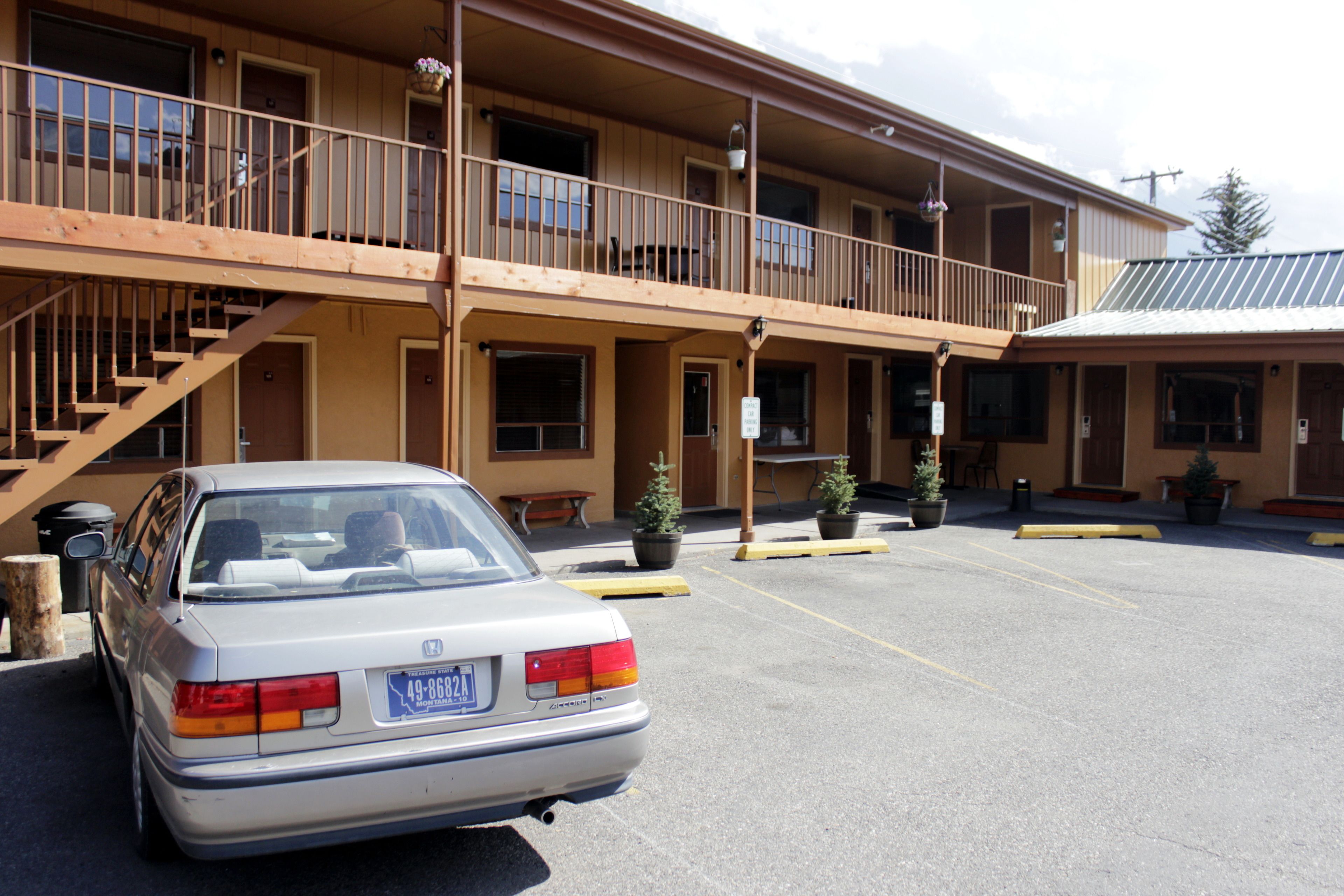 Een motel met twee verdiepingen, met een auto ervoor geparkeerd.