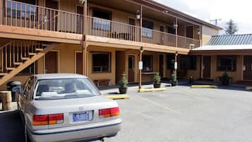 Een motel met twee verdiepingen, met een auto ervoor geparkeerd.