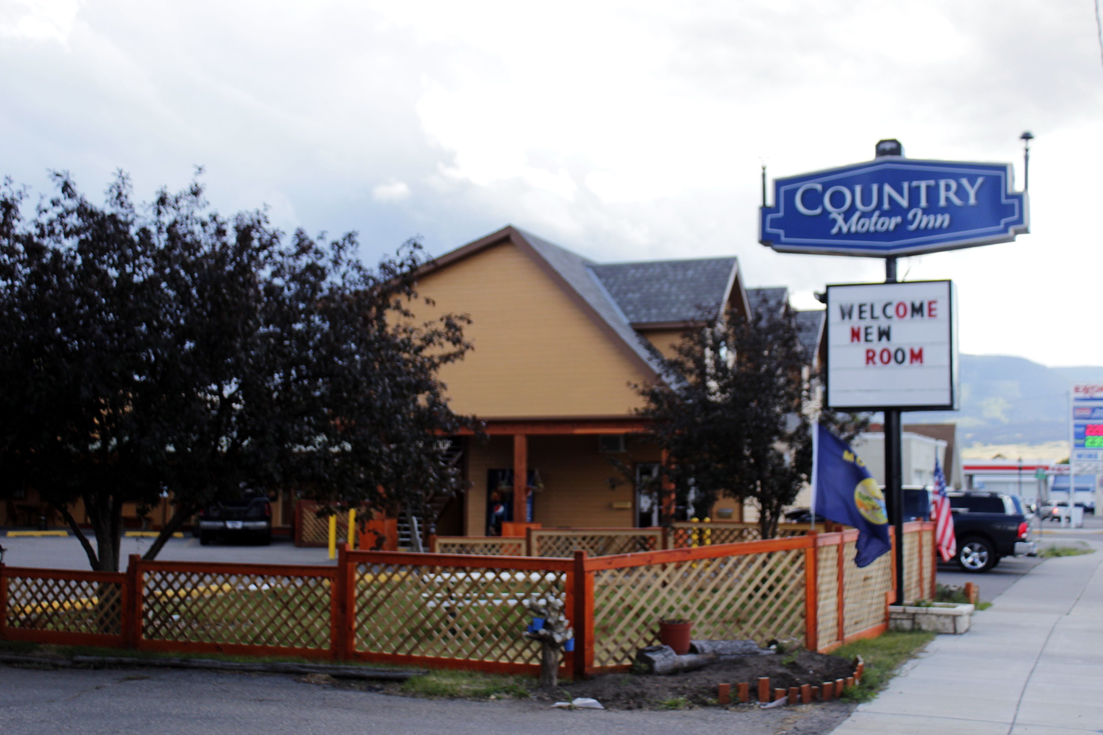 A Country Motor Inn with a welcoming sign and a fenced outdoor area.