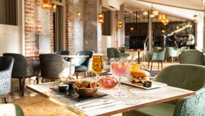 A restaurant interior with brick walls, modern lighting, and a variety of seating options. - Hotel Kilkenny (Kilkenny)
