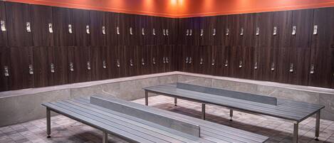 A locker room with multiple lockers and benches.