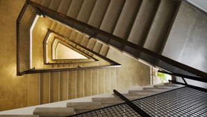 Una escalera de caracol con un diseño geométrico y barandilla de metal.
