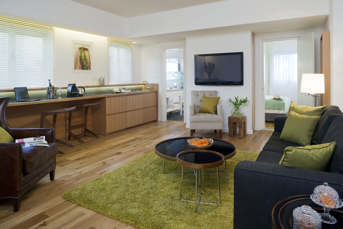 A modern living room with a sofa, coffee table, and a TV mounted on the wall.