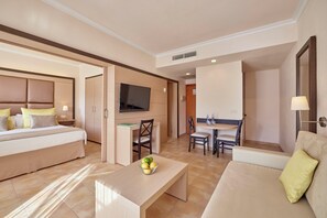 Een moderne hotelkamer met een bed, een bureau, een zithoek en een televisie.