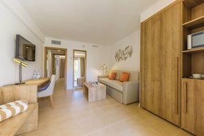 Una sala de estar moderna con sofá, una mesa de centro, un televisor montado en la pared y un aparador de madera.