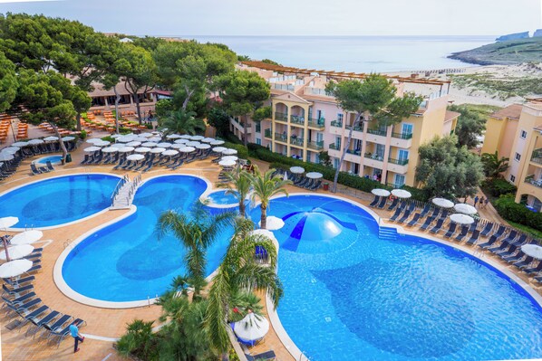A resort with multiple swimming pools, sun loungers, and a view of the sea. - Zafiro Cala Mesquida (Capdepera)